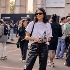 woman in a white top and black pants at Paris Fashion Week 2023