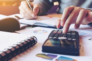 Man doing taxes by hand with calculator