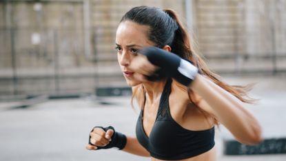 Woman in fitness gear completes a boxing workout