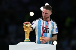 Alexis Mac Allister touches the World Cup trophy after Argentina's win at Qatar 2022.