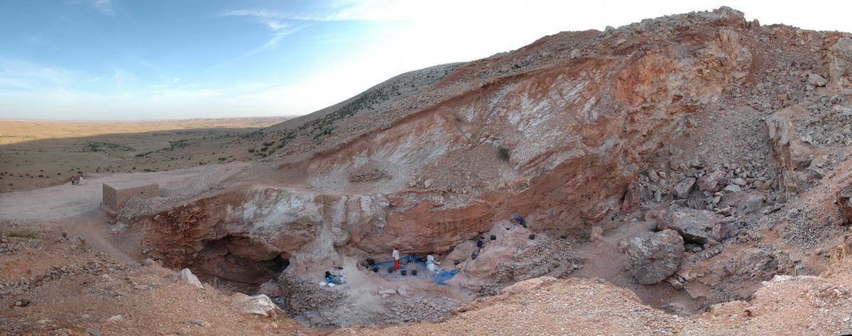 The oldest bones of &lt;em&gt;Homo sapiens&lt;/em&gt; were found at the archaeological site of Jebel Irhoud. Here, a view of the site showing the remaining deposits and people excavating them (center). Some 300,000 years ago, this site, which would have been a cave, 