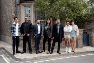 Nugget, Ravi, Vinny, Suki, Nish, Avani and Priya standing outside 41 Albert Square.