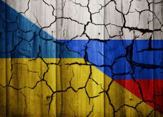 A mockup image depicting a fractured relationship between Ukraine and Russia with cracks appearing across both flags