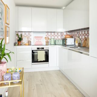 grey gloss kitchen units and pink tiles