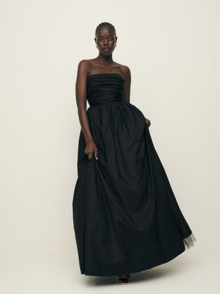 Reformation model wearing black maxi dress with ruched bodice