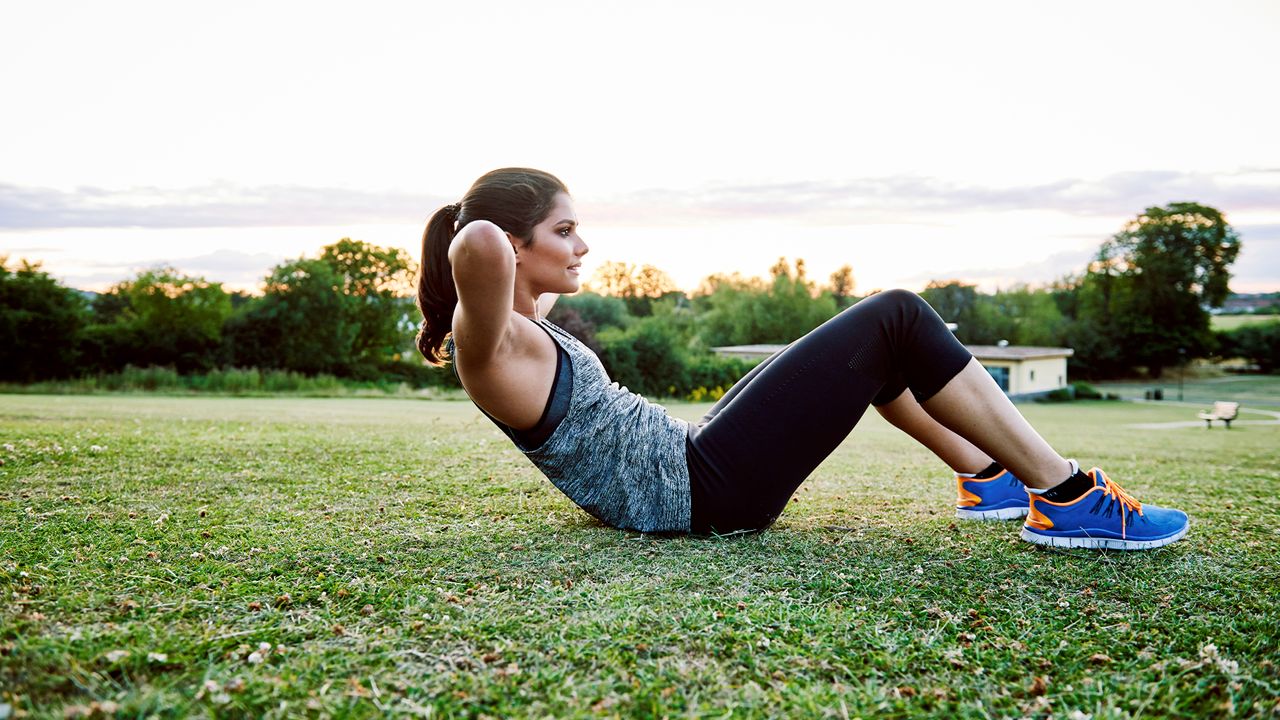 person doing sit-ups outside