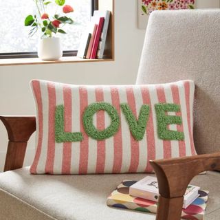 A rectangular cushion in red and white stripes, emblazoned with the word LOVE in green