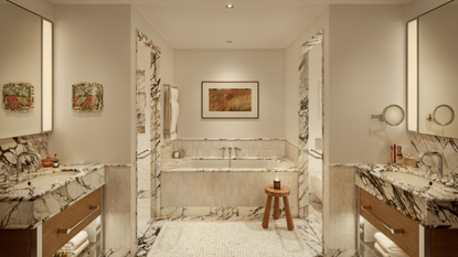 marble bathroom with double vanities, a built-in tub, and marble architraves around the doorways