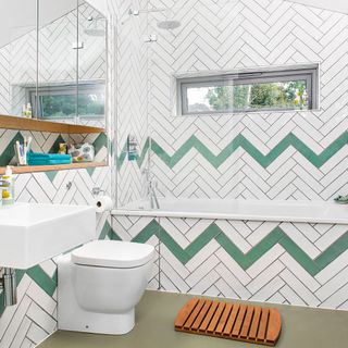 bathroom with white designed tiles wall commode and mirror