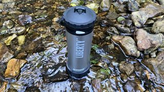 Blue LifeSaver Liberty Purifier in shallow water on wet rocks