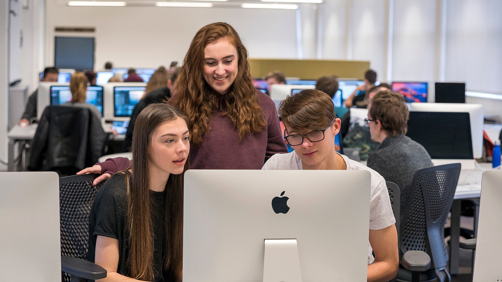 Students using Apple devices in a classroom.