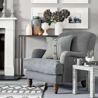 grey wall with fireplace and armchair with cushion