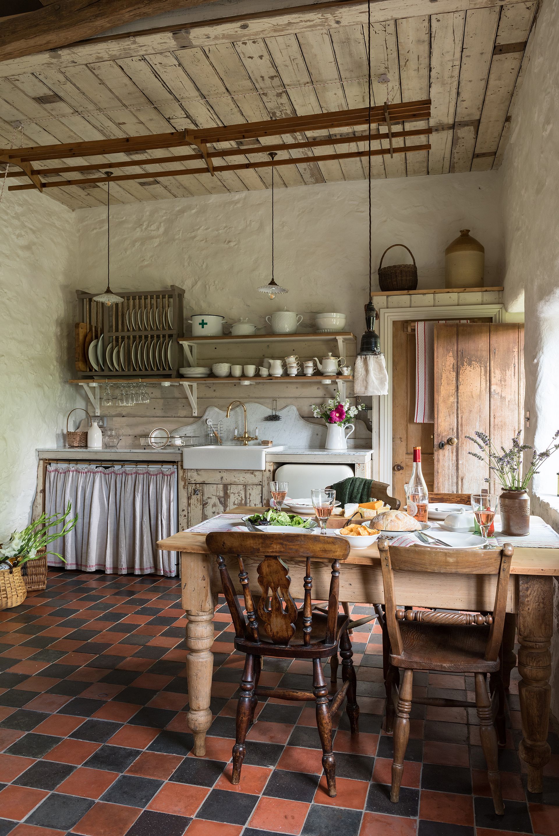 cottage kitchen with tiled red and black tiles and wooden furniture