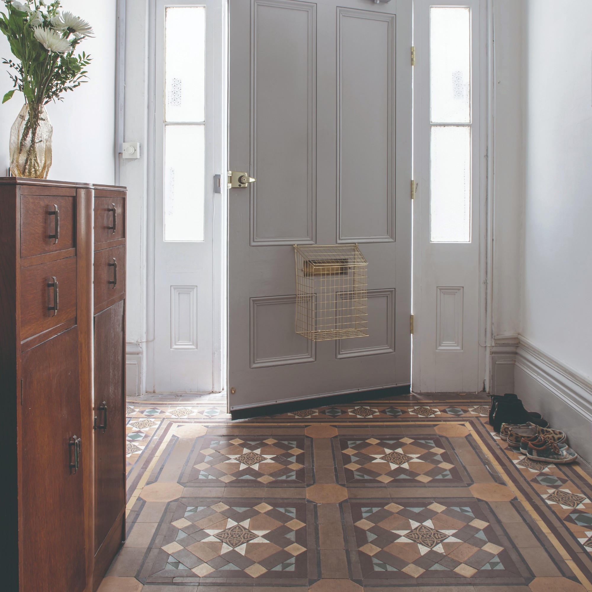 A hallway with Victorian mosaic tiled flooring