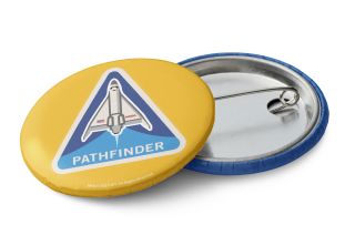 the front and back of a small yellow button featuring an image of a space shuttle.