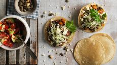 Black bean tostadas with a bowl of salsa and some pumpkin seeds