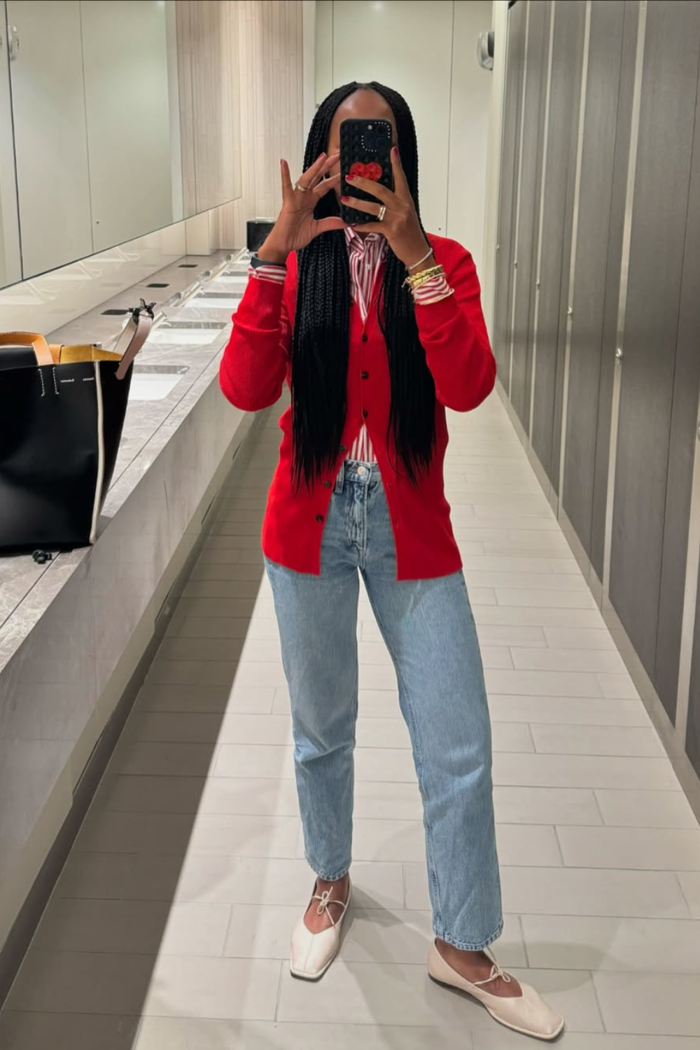 @thandimaq wears jeans, red cardigan, white ballet pumps