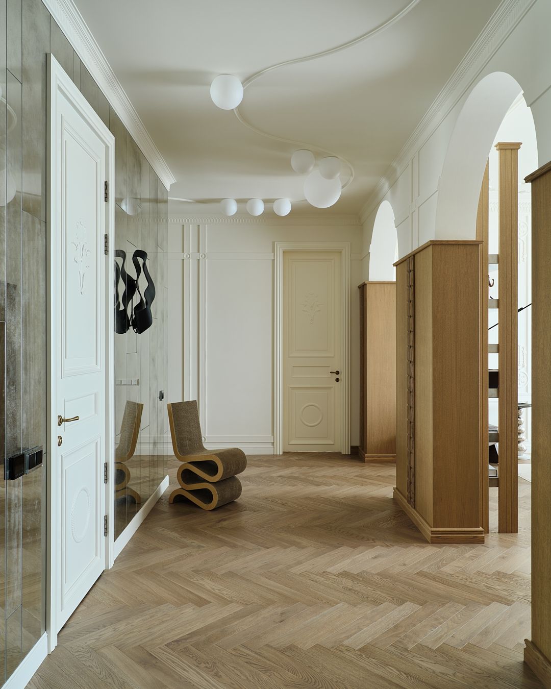 A herringbone floored entry with a aged mirrored wall