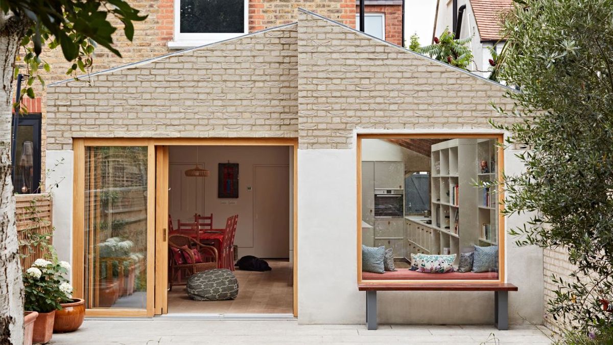 contemporary pale brick and render rear terrace house extension with large timber framed picture window and sliding patio doors