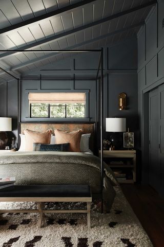 a dark grey bedroom with a window behind the bed