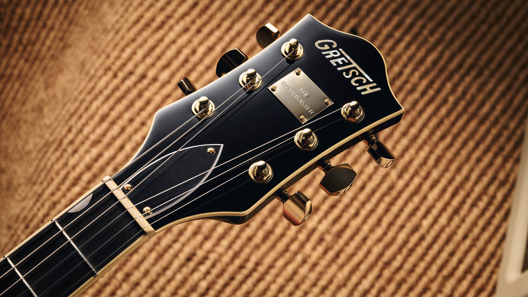 Gretsch Professional Collection Broadkaster LX Center Block: the handsome semi-hollow is finished in black with gold hardware and here is photographed in close-up.
