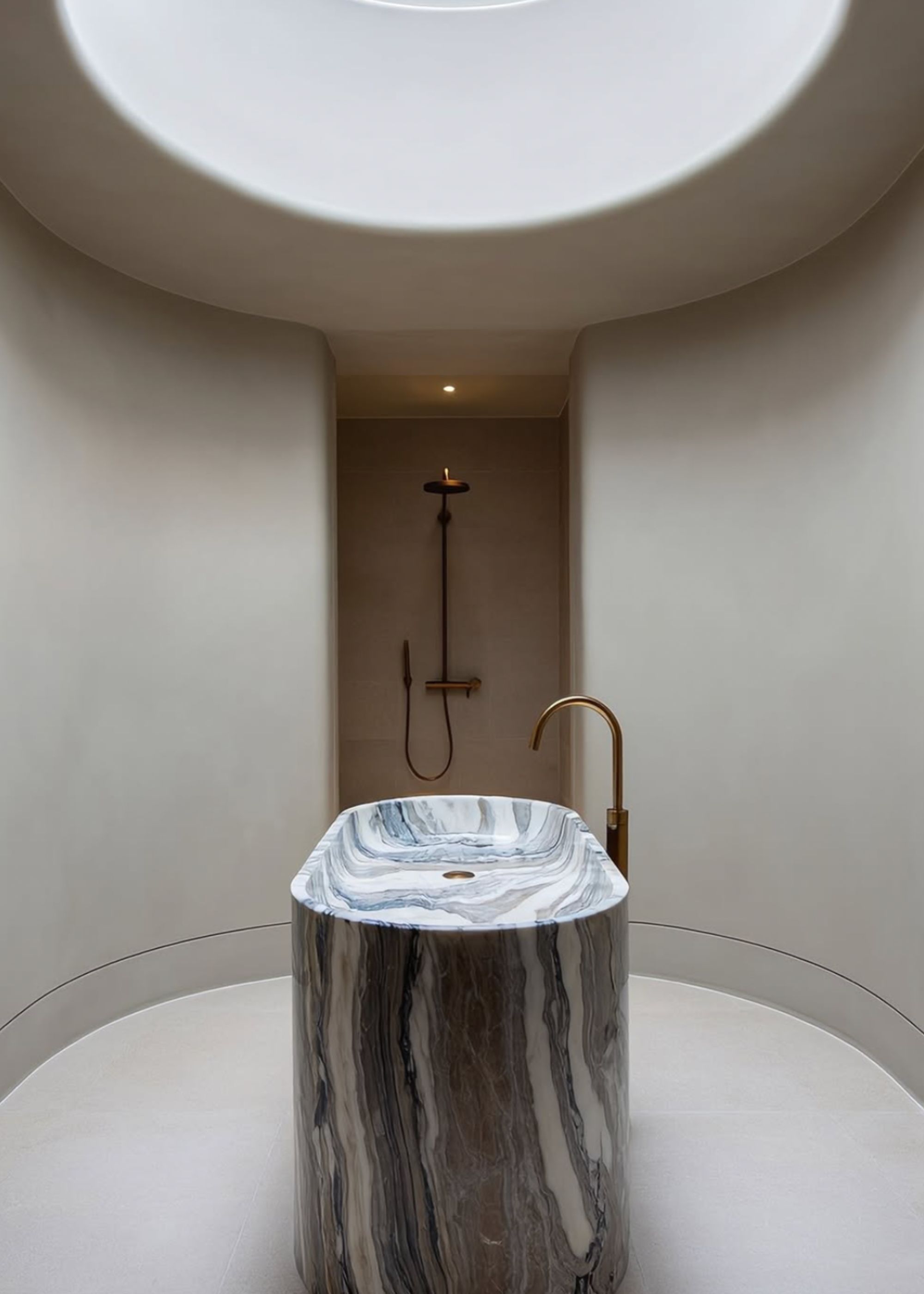 A bathroom with a marble sink in the centre, and an LED light well right above it