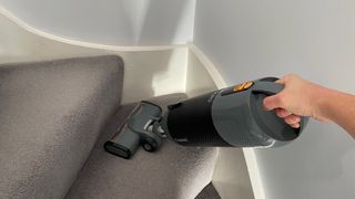 The Halo Capsule in handheld mode being used to vacuum stairs