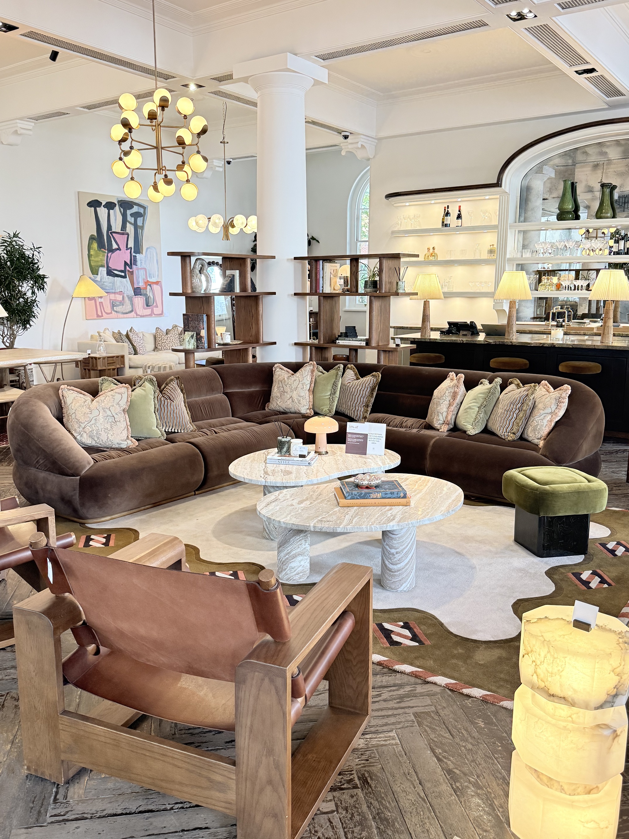 Soho Home Edison Modular Corner sofa in showroom with armchair, rugs, coffee table, cushions, and lighting