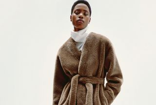 A Zara model wears a white turtleneck and a fur coat.