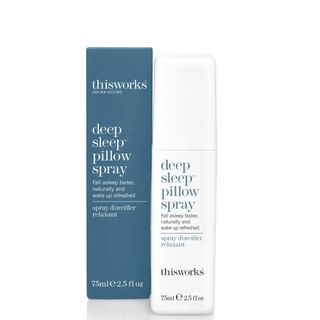 A white bottle and a blue box to the left of This Works Deep Sleep Pillow Spray.
