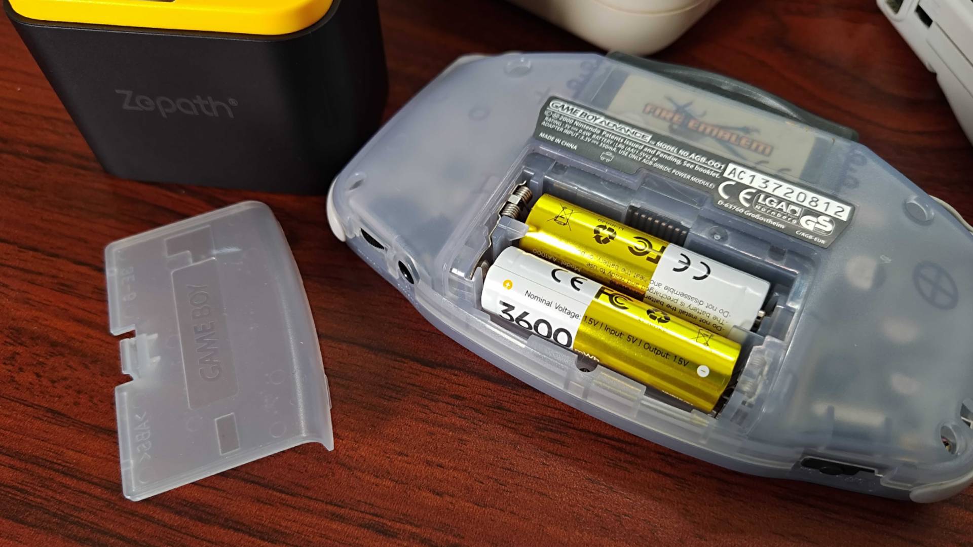 Rechargeable batteries within transparent Game Boy Advance with cover removed.