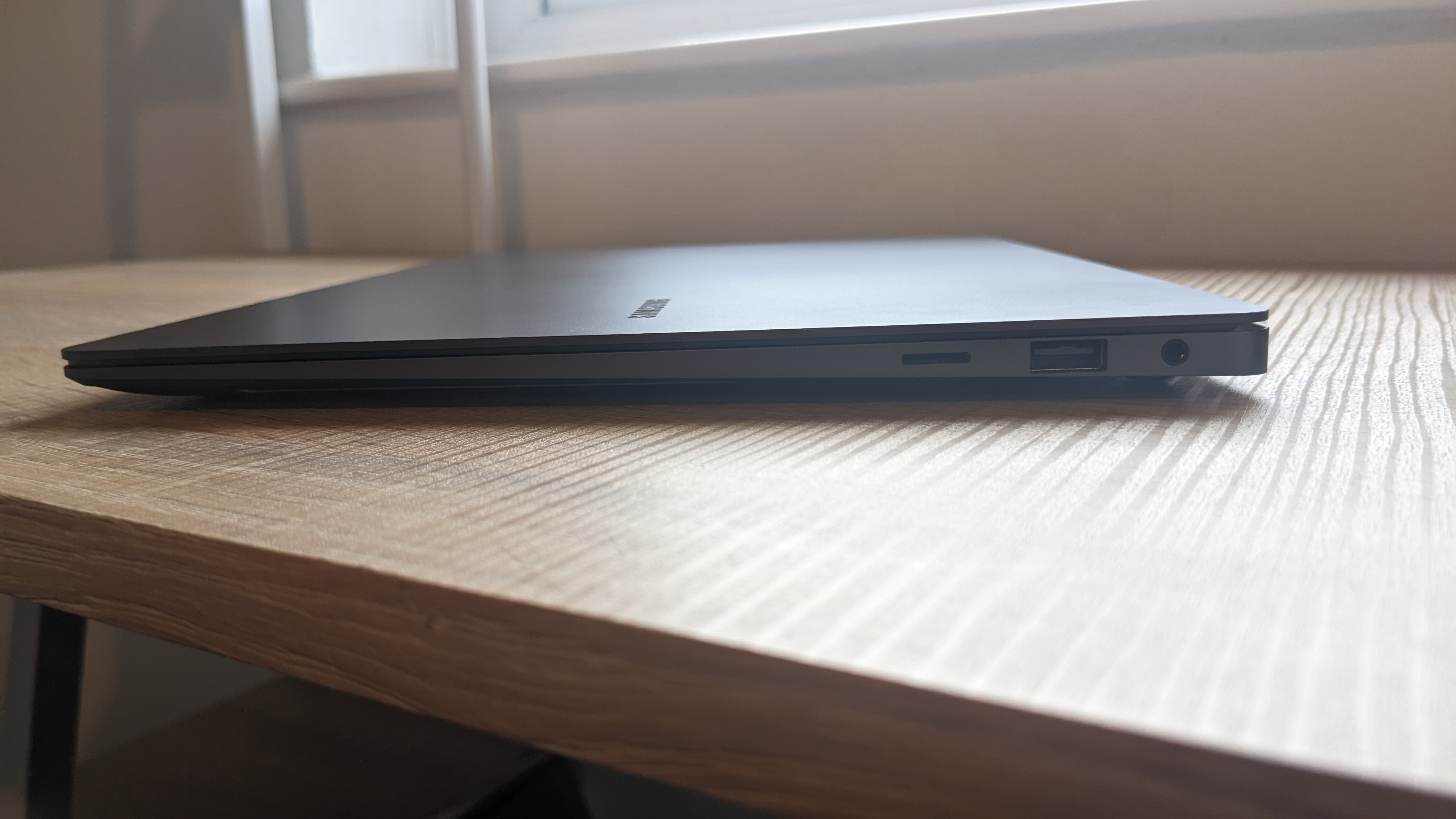 The Samsung Galaxy Book3 Pro 14-inch laptop pictured atop a wooden desk.