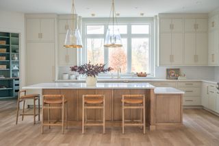 Benjamin Moore's skipping stone paint on cabinets in a natural light-filled kitchen.