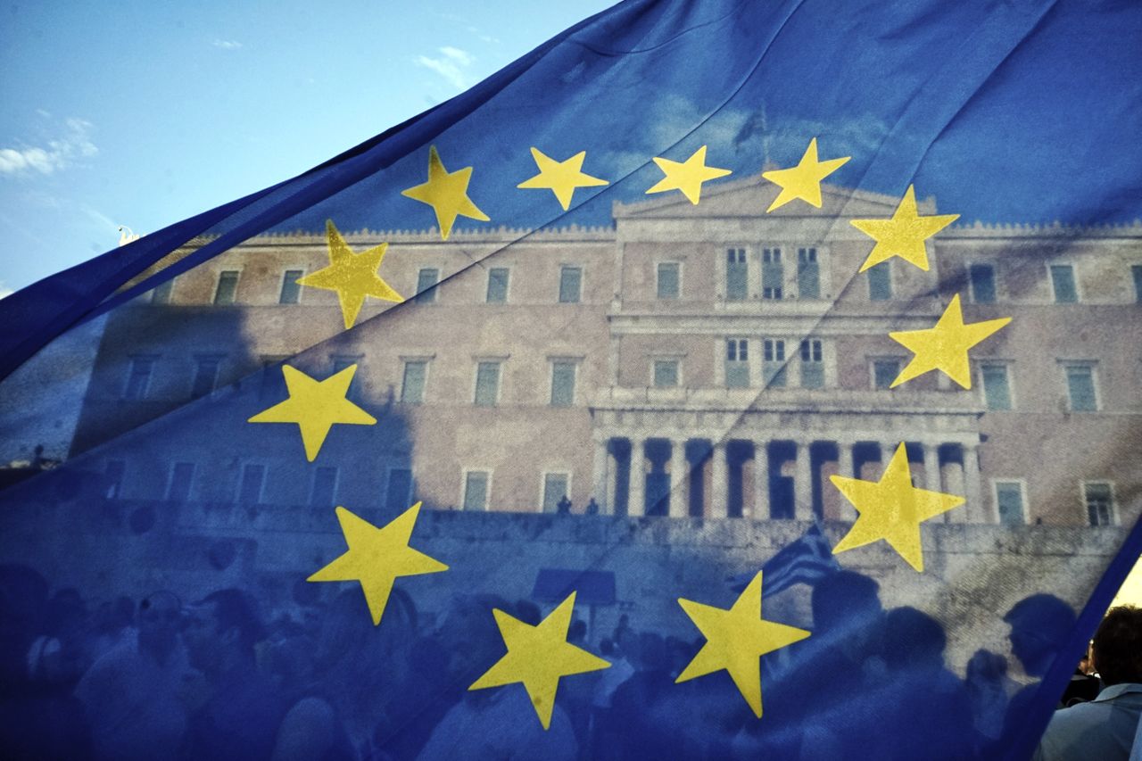 An EU flag flutters in front of the Greek parliament