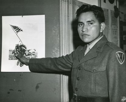 Marine Private First Class Ira Hayes illustrates the part he played in the raising of the flag at Iwo Jima.