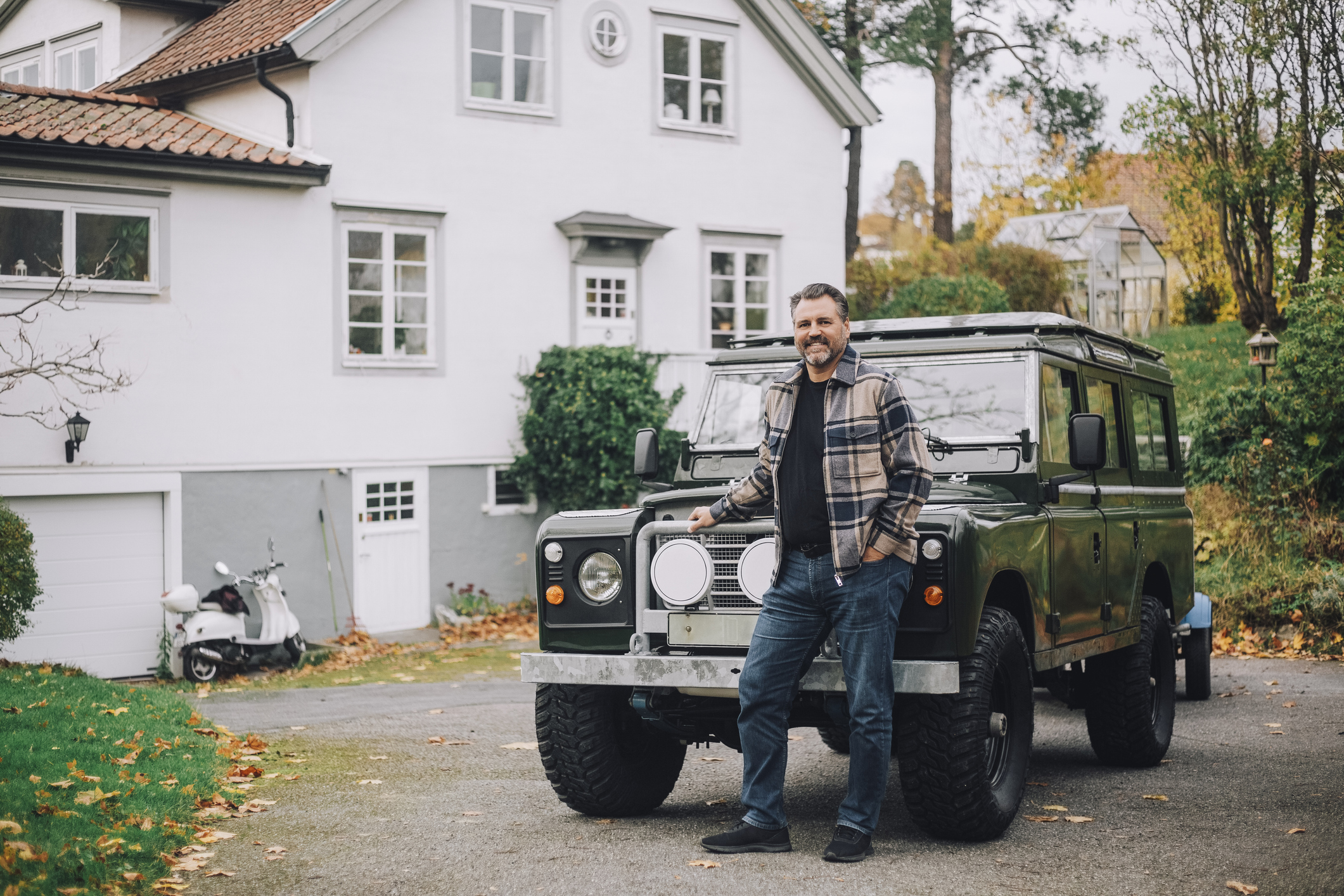 a man standing in front of his Jeep at his home