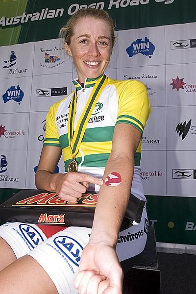 Open women's time trial champion Amber Halliday points to her tattoo in respect for the late Amy Gillett who competed in these championships before she was tragically killed in a car accident in Germany.