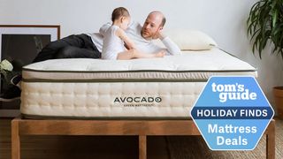 A man and his baby sit and play on top of the Avocado Green Mattress