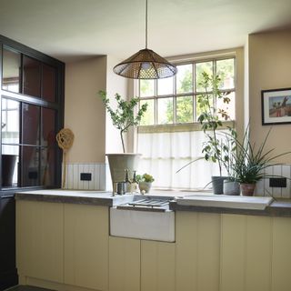 country kitchen with belfast sink and plants around the window