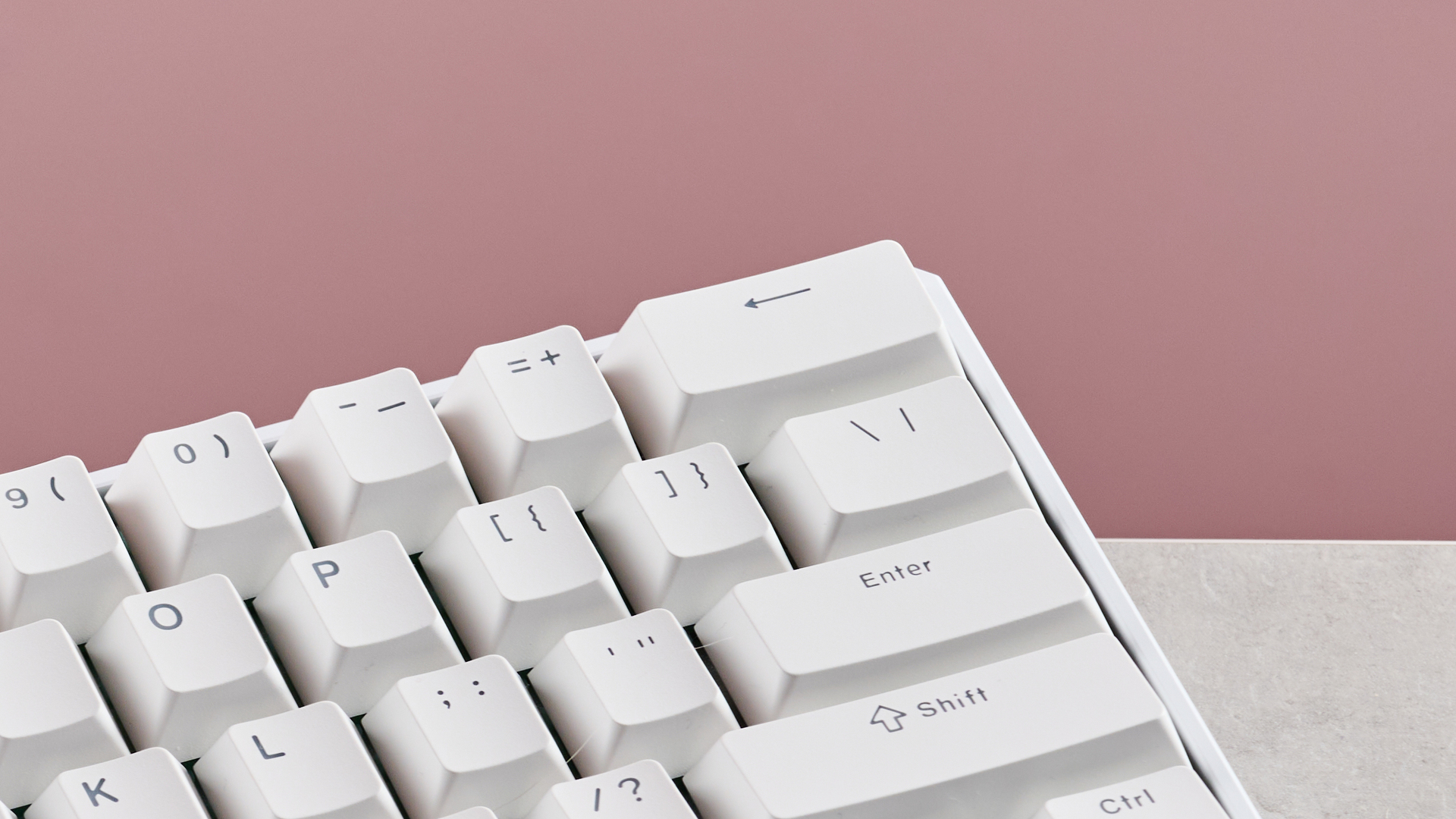 Close-up of top right keys on MonsGeek FUN60 Ultra, on desk with pink background