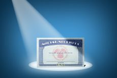 A Social Security card in the spotlight on a blue background.