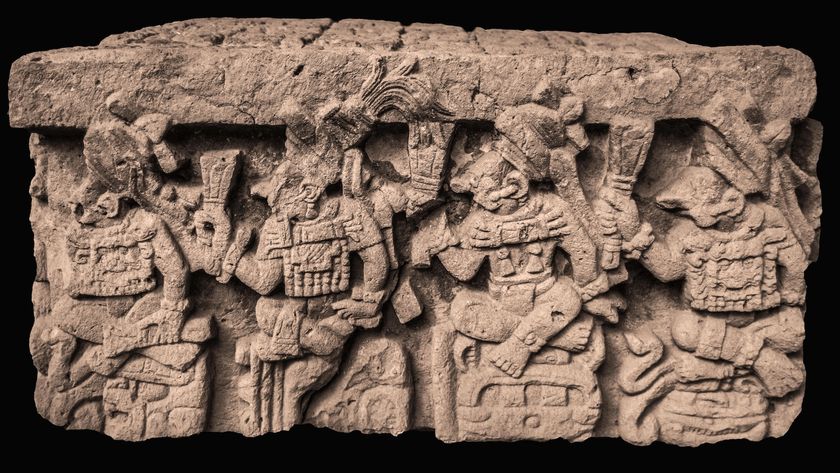 A side view of an intricately carved altar depicting Maya people