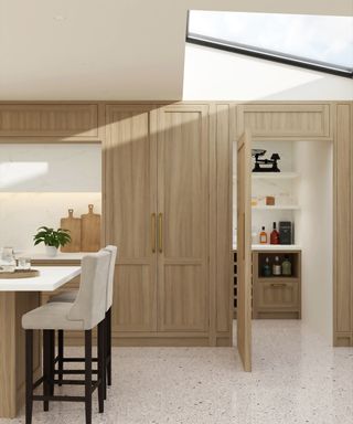 wooden floor to ceiling kitchen units with door next leading to utility area