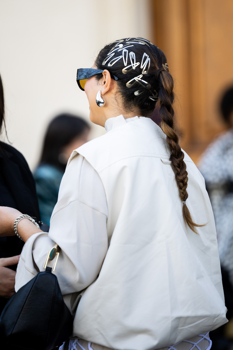 A woman with plaited ponytail wears silver hairpins