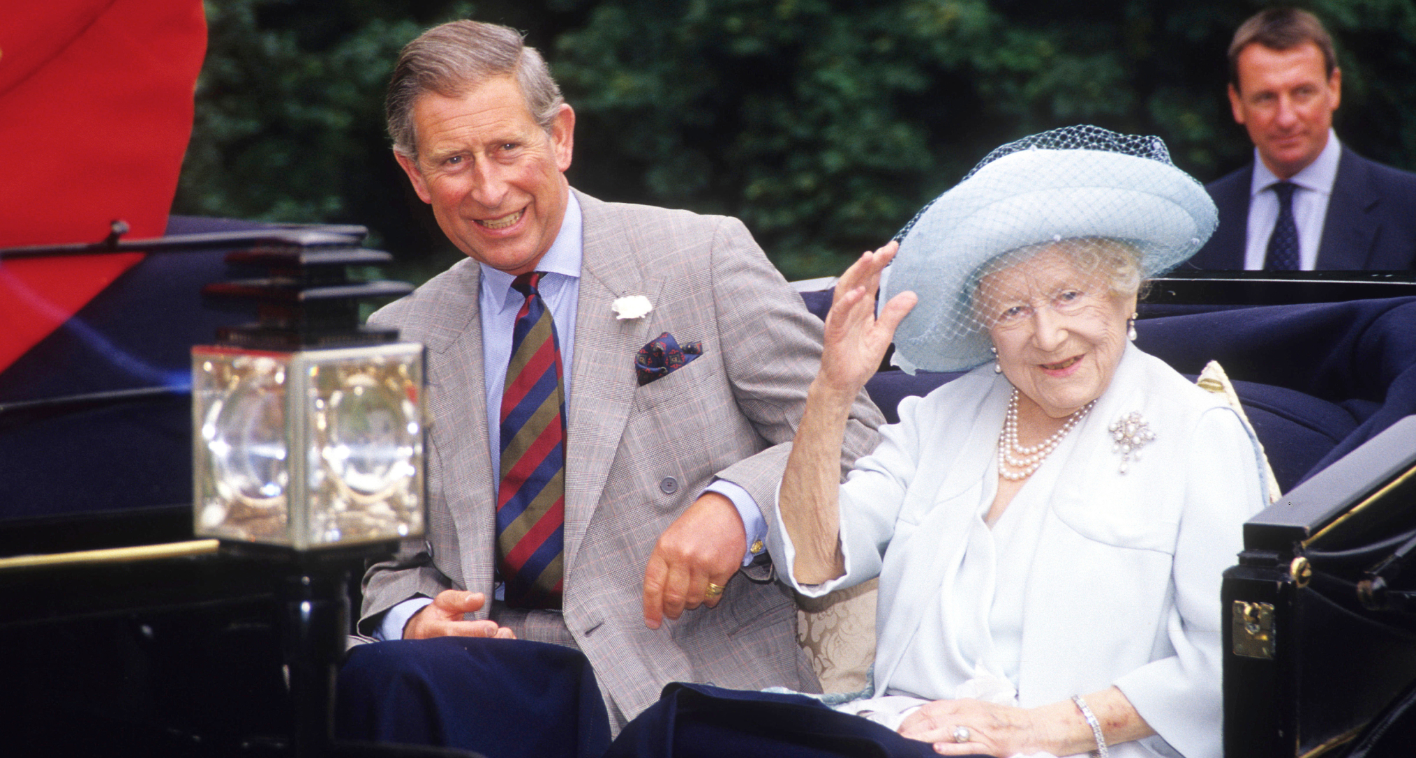 King Charles sitting in a carriage with the Queen Mother