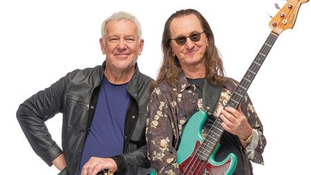 Rush's Alex Lifeson and Geddy Lee pose with their Gibson ES-355 and Fender Jazz Bass