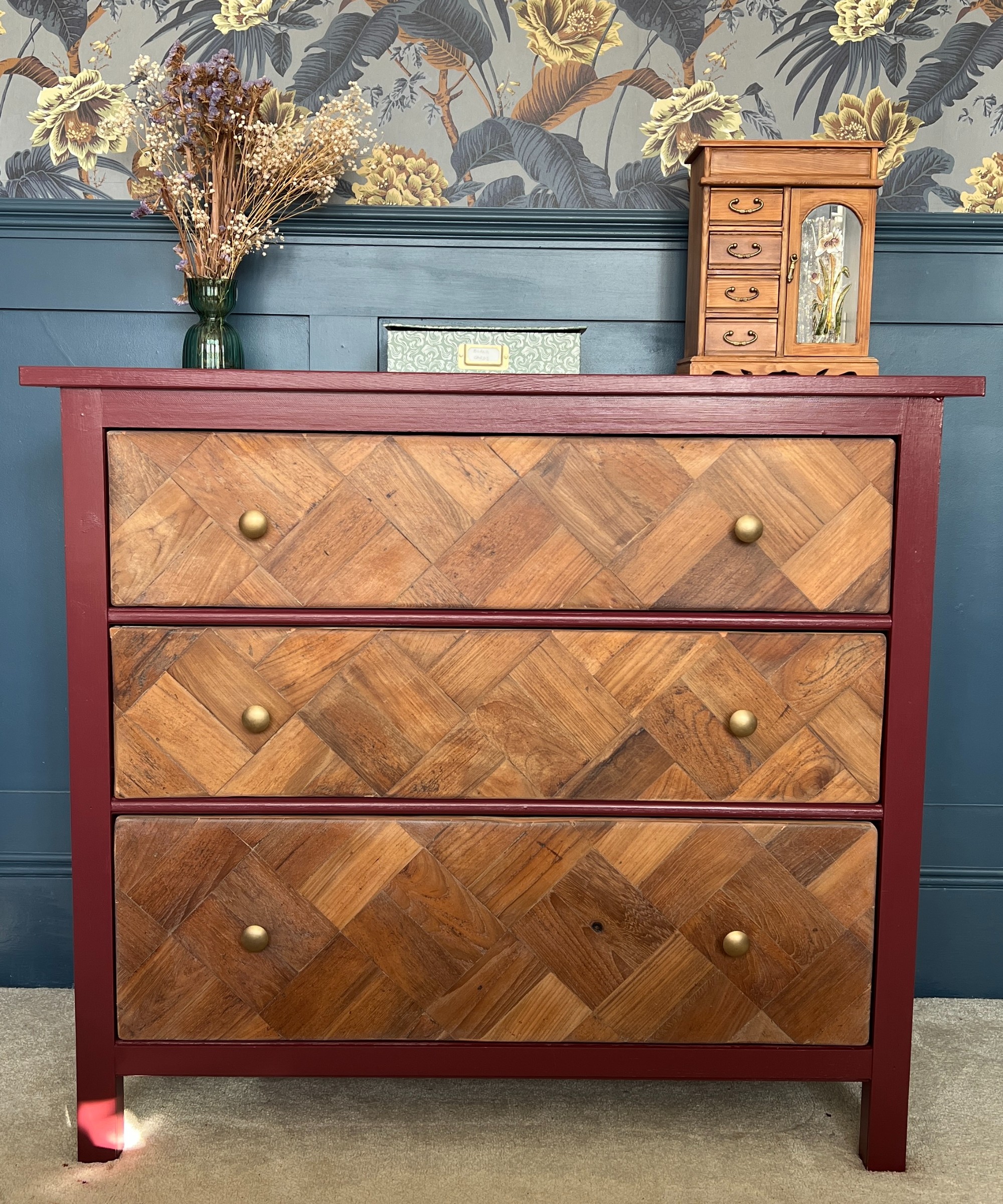 IKEA HEMNES dresser adorned with reclaimed parquet flooring and painted dark red set against a half wallpaper-covered wall with a dado rail