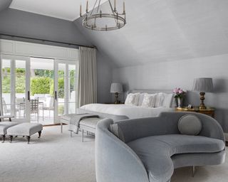 A grey bedroom with blue velvet sofa