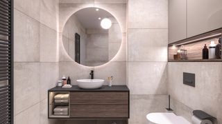 Modern marbled bathroom with walnut wood vanity sink unit and large round mirror