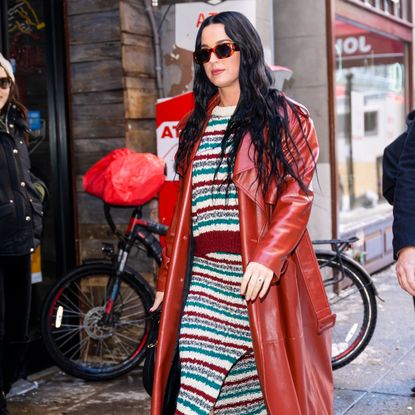 Katy Perry in a striped wool dress, red leather jacket, and red leather boots